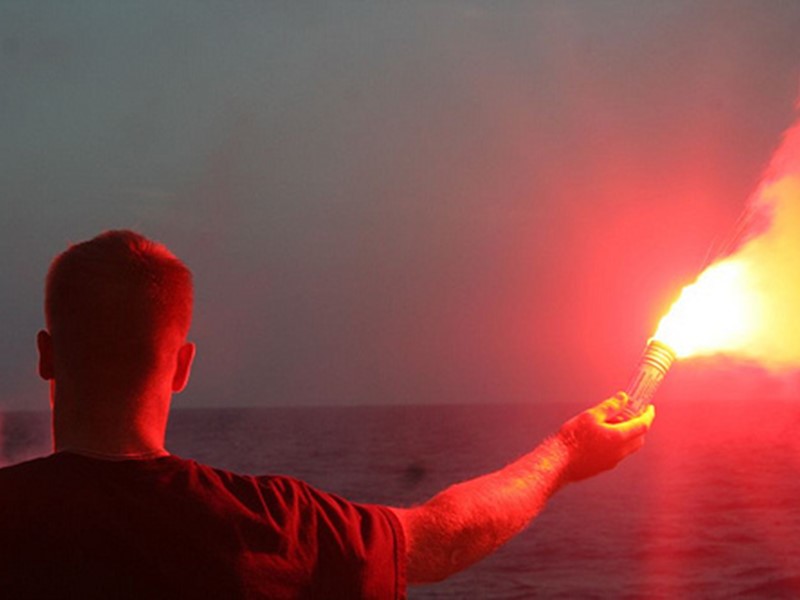 Man holding red handheld flare