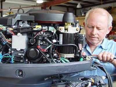 Man working on outboard engine